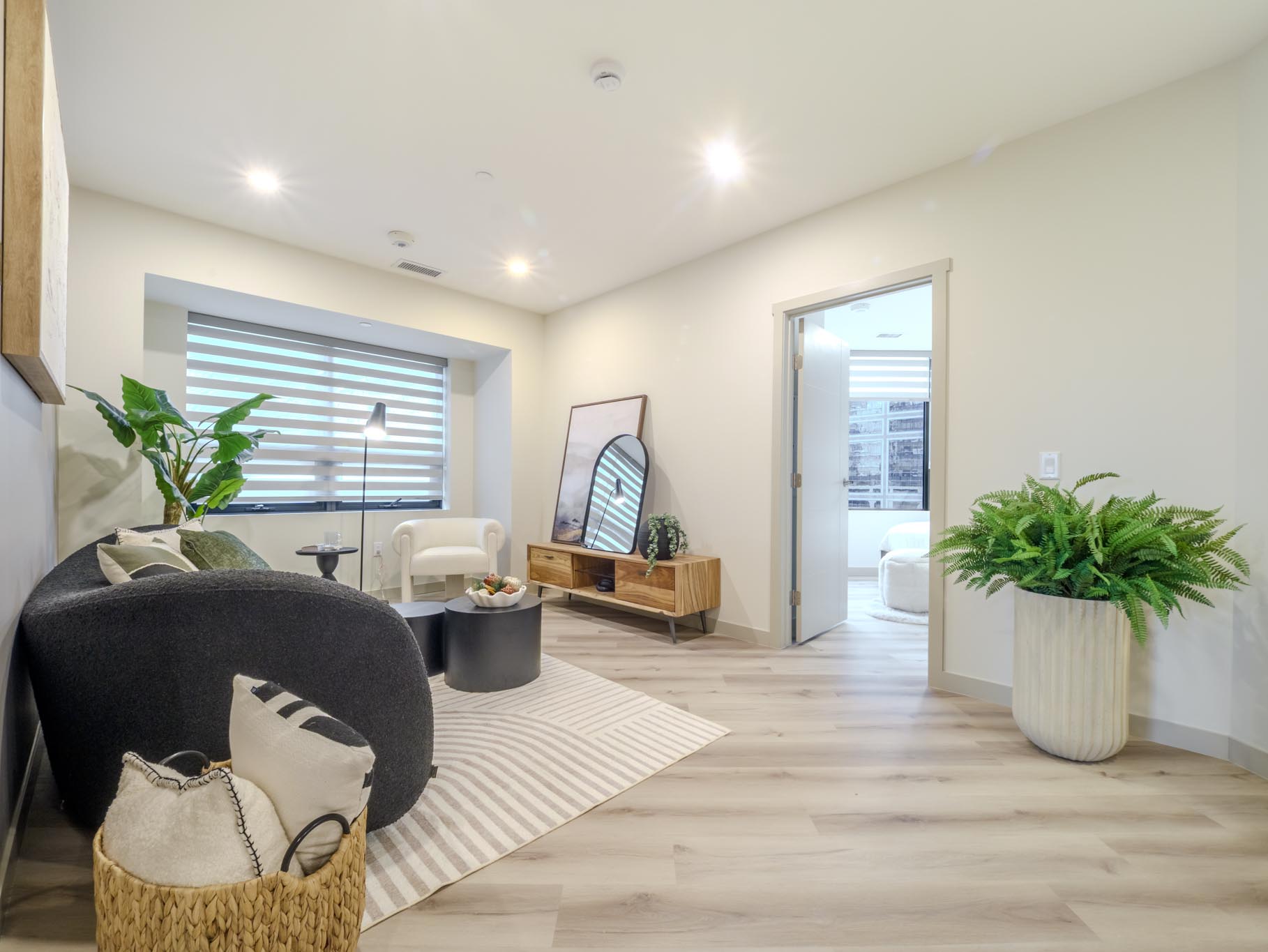 Bright suite living room with a sofa, lounge chair and large window